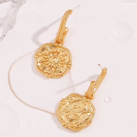 Visão detalhada dos brincos de aço inoxidável PVD dourado com tema celestial.