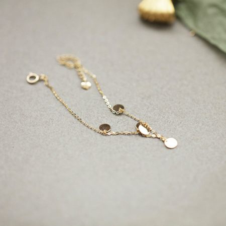 Een delicate vergulde kettingarmband met verschillende charms, inbegrepen in de sterling zilveren set.