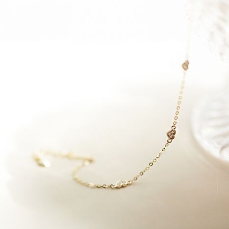 Vista en primer plano de la cadena y el cierre de plata esterlina chapada en oro de la pulsera en forma de corazón.