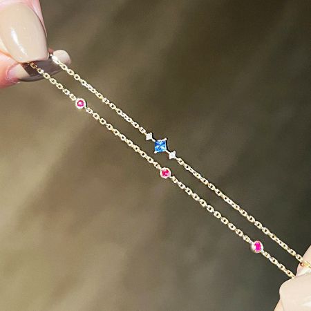 Vollansicht des zweilagigen Goldkettearmbands mit mehreren bunten Zirkonsteinen.