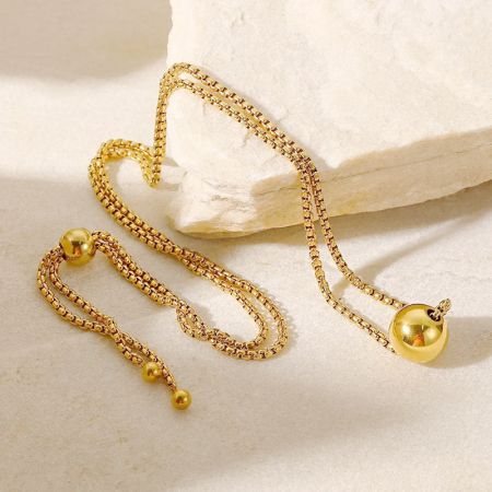 Detaillierte Ansicht der goldenen Zugkette und des sphärischen Anhängers.