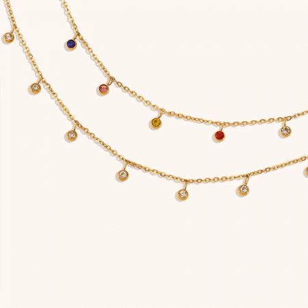 Collar colgante de zirconia multicolor de oro delicado para mujeres en acero inoxidable, set de 5 - Una toma promocional que muestra dos collares de acero inoxidable en tono dorado, uno con vibrantes piedras de zirconia multicolores y el otro con clásicas piedras de zirconia blanca.