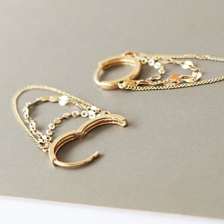Immagine principale degli orecchini a cerchio a forma di mezzaluna con delicati pendenti a catena.