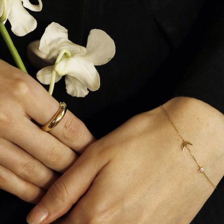 A pulseira de charme celestial estilizada com um anel de ouro combinando.
