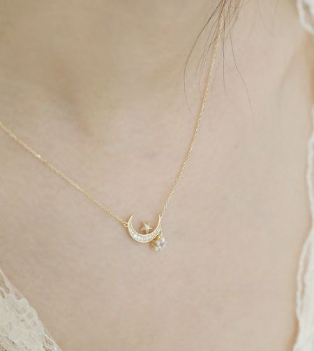 Collar de Luna y Estrella de Plata Esterlina 925 - Un primer plano del collar de luna y estrella de plata esterlina 925, que muestra el detallado colgante de luna creciente y estrella chapado en oro, adornado con piedras de circonio cúbico brillantes.