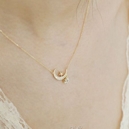 Detailed shot of the gold-plated star and moon pendant, emphasizing the brilliant zircon stones.