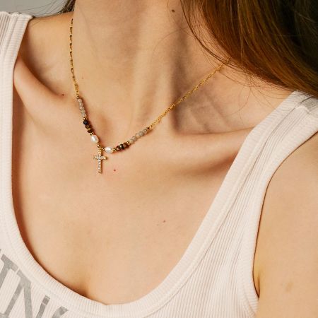 Un autre angle du collier croix en acier inoxydable, se concentrant sur l'éclat du pendentif.