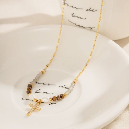Le collier croix en or présenté avec des perles multicolores, montrant sa polyvalence.