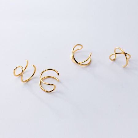 Un set di quattro orecchini a bracciale curvo dorati, che mostrano la varietà del prodotto.