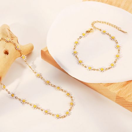Elegante gouden kettingarmband met delicate witte madeliefjes charms.