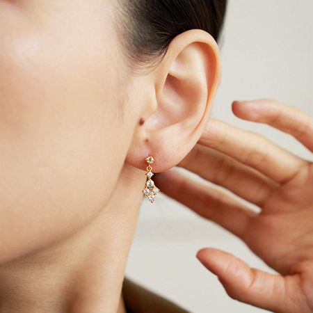 A leaf-like design 18k gold plated dangling earring with clear cubic zirconia gems.