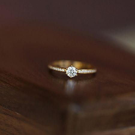 Detailed product shot of the six-prong solitaire ring, showcasing the brilliant center stone and polished band.
