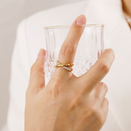 モデルの手に着用された調整可能な金のジルコンリングを示すライフスタイル画像。