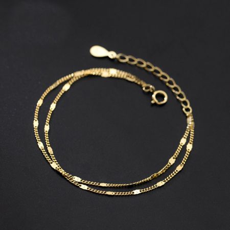 Vue détaillée de la chaîne à double couche et du fermoir du bracelet en or.