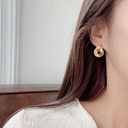 Un modello che indossa l'orecchino a perno multi-strato in oro per mostrare la sua dimensione e stile.