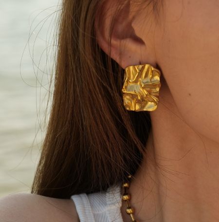 Pendientes de acero inoxidable metálico dorado - Foto de producto en primer plano de pendientes de acero inoxidable metálico dorado con un collar a juego, mostrando su brillante acabado dorado y diseño elegante.