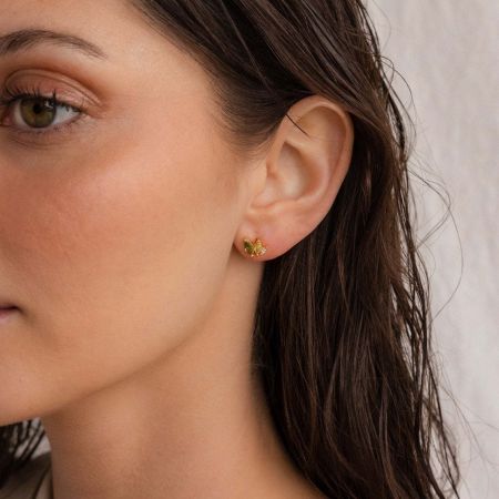 Close-up van de minimalistische marquise CZ stud oorbel die wordt gedragen, met de nadruk op de gouden setting.