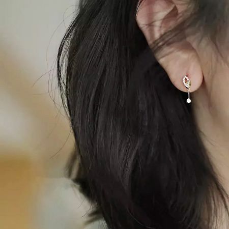 Pendientes mini colgantes de hoja chapados en oro de 14K de plata esterlina 925 para mujeres - Primer plano de un pendiente mini colgante de hoja de plata esterlina 925 con chapado en oro de 14K y zirconia cúbica brillante.