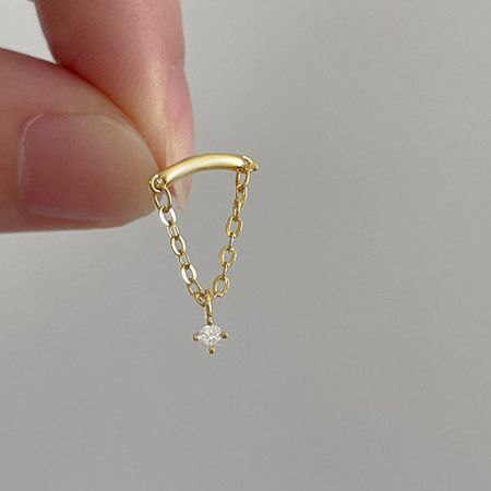 Vista dettagliata dell'orecchino a catena a frange dorato con un delicato ciondolo a forma di diamante.