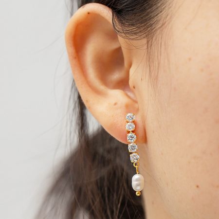 Model met de roestvrijstalen parel en zircon franje oorbel om de elegante hang en grootte te tonen.