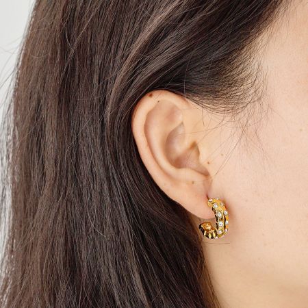Otro ángulo del pendiente de zirconia en forma de C en la oreja de un modelo.