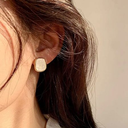 Close-up of the earring being worn, highlighting its sophisticated look.
