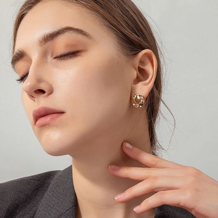 Modelo que muestra los elegantes pendientes de poste en forma de triángulo dorado, perfectos para el uso diario.