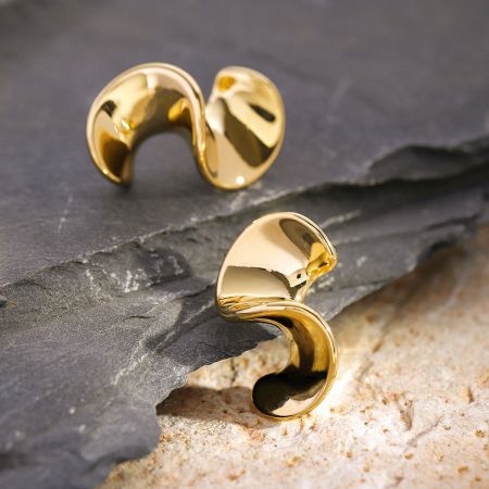 Pendientes de Oro Geométricos con Forma de Ola de Acero Inoxidable (5 pares) - Un par de pendientes de oro con forma de ola geométrica de acero inoxidable sobre un fondo blanco limpio, mostrando su diseño curvado único.