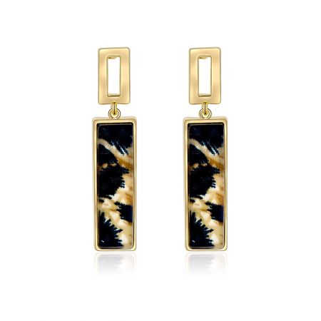 Pendientes de stud con estampado de leopardo. - Un par de pendientes de stud con estampado de leopardo hechos de latón chapado en oro, con un distintivo inserto de patrón negro y dorado, mostrado sobre un fondo blanco.