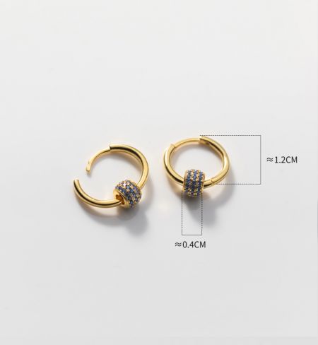Primo piano dettagliato degli orecchini a cerchio in argento sterling 925 placcati in oro che mostrano l'intricato incastonatura di pietre blu.