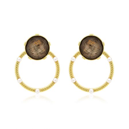 Pendientes de oro con resina brillante marrón - Una vista en primer plano de los pendientes de oro con resina brillante marrón, mostrando el latón chapado en oro, la resina marrón brillante y los delicados detalles de perlas blancas.