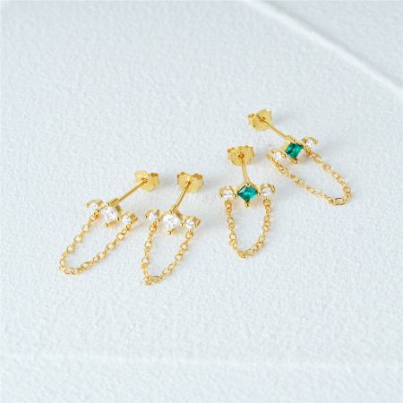 Un assortimento di orecchini a frangia dorati con opzioni di zirconio chiaro e verde.