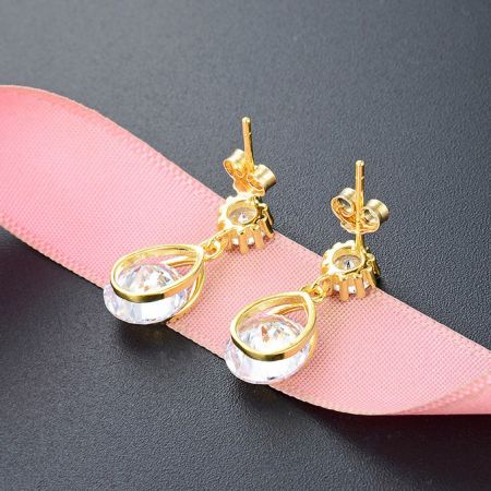 Un paio di orecchini a goccia placcati in oro con zirconia bianca, mostrati da un'angolazione diversa.