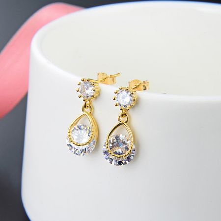 Un'altra prospettiva degli eleganti orecchini a goccia in oro, che enfatizza la combinazione di pietre zirconia a goccia e rotonde.