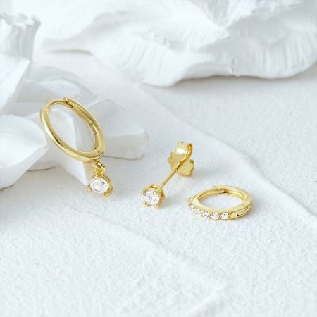 La versione placcata in oro del set di orecchini in argento sterling 925 con zirconia, caratterizzato da vari design di orecchini a perno e a cerchio.