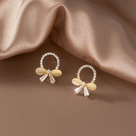 Detailed shot of the bow earrings highlighting the clear and light-colored oval stones.