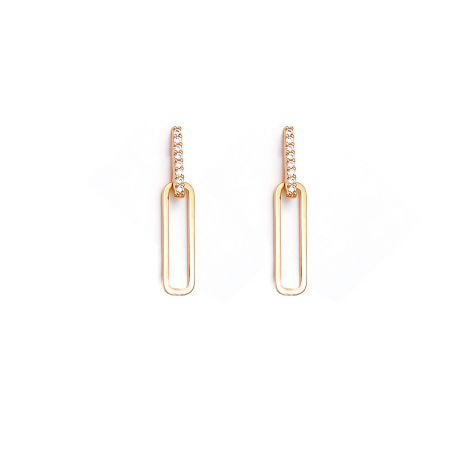 Vue détaillée des boucles d'oreilles pendantes en or en forme de trombone avec des pierres en zircon cubique transparent.