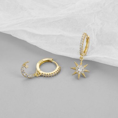 Primer plano de los pendientes de estrella y luna creciente que muestran los brillantes acentos similares a diamantes.