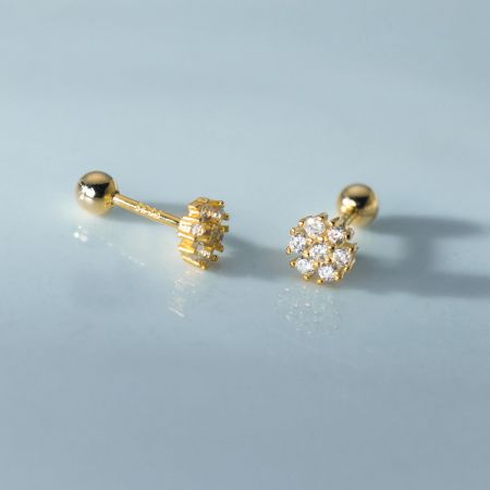 Close-up of the gold flower earrings with a brilliant cluster of clear cubic zirconia stones.
