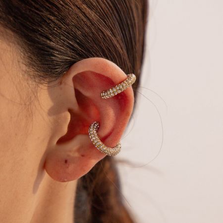 Pendientes de aro de clip de strass color dorado de acero inoxidable (5 pares) - Un primer plano de dos pendientes de aro de clip de acero inoxidable color dorado adornados con brillantes strass blancos, mostrando su elegante diseño.