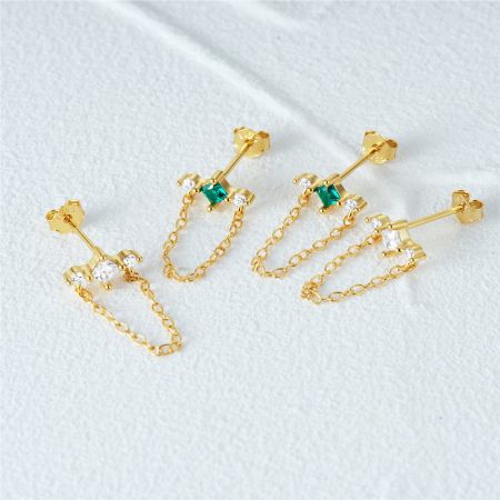 Una collezione di tre paia di orecchini a frangia in zirconio placcato oro che mostrano stili diversi.