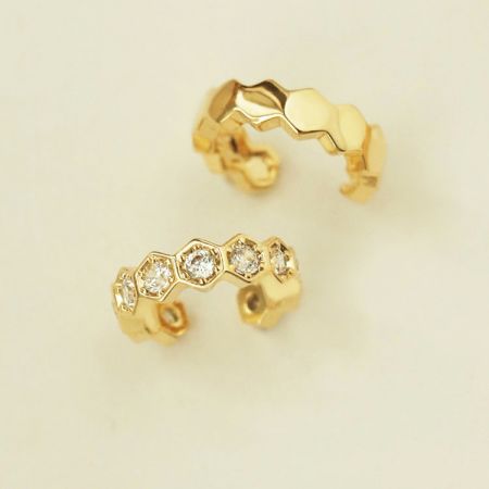 Vergulde 925 zilveren oorcuffs zonder piercing (set van 5 paar) - Een paar vergulde 925 zilveren mismatched oorcuffs, de ene met een gladde afwerking en de andere versierd met sprankelende edelstenen, op een witte achtergrond.