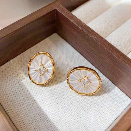 贈り物に最適な木製のジュエリーボックスに入ったジルコニアスタッドイヤリングのペア。