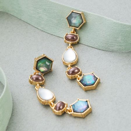 Vista completa del pendiente vintage dorado que exhibe la intrincada disposición de piedras preciosas multicolores.