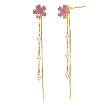 Gros plan des boucles d'oreilles pendantes Pearl Blossomed, mettant l'accent sur la fleur rose à cinq pétales et les multiples perles pendantes.