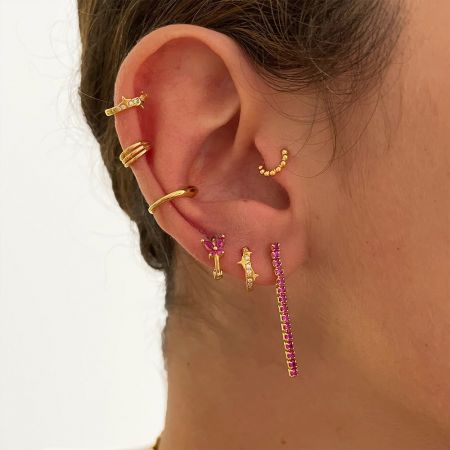 Model showcasing how to style multiple huggie earrings.