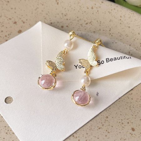 Another design from the set: gold butterfly earrings with pink gems and pearls.