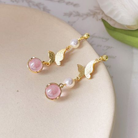 Elegant gold drop earrings featuring a leaf design with pink gemstones and pearls.