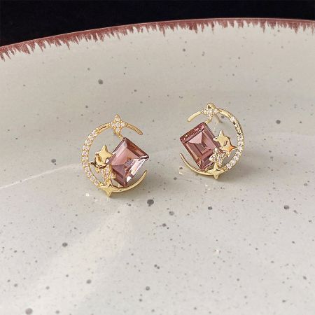 Vista detalhada dos brincos de estrelas e luas banhados a ouro 14k, destacando os designs.