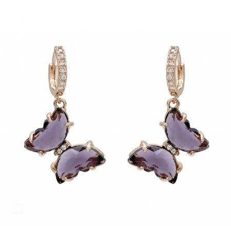 Boucles d'oreilles huggie en papillon violet - Gros plan sur les boucles d'oreilles huggie en papillon violet (JRE-113), mettant en avant le laiton plaqué or, le cristal violet scintillant et les accents en zircon cubique blanc.